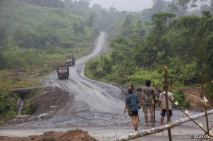 Penan armed with blowpipes block road as logging trucks owned by  the Shin Yang company approach.